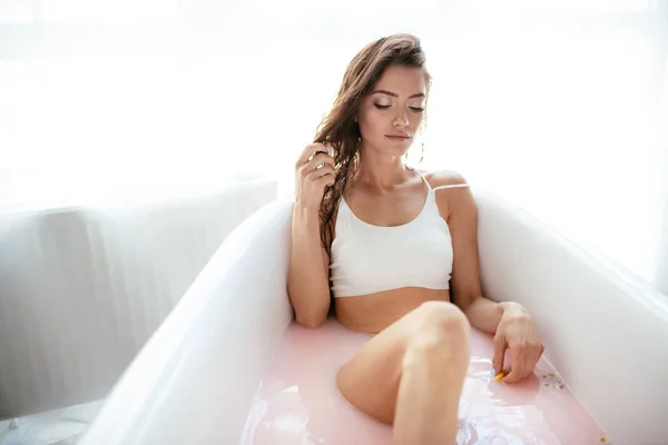 Kobieta relaksująca się w mlecznej kąpieli w uzdrowisku. Koncepcja wellness i dobrego samopoczucia — Zdjęcie stockowe