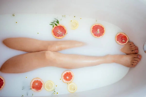 Vacker sexig kvinna i mjölkbadet med frukt — Stockfoto