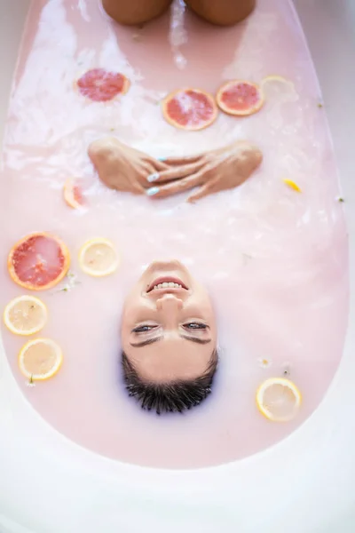 Visage de femme dans le bain de lait. Spa concept de soins de la peau. Visage sain et rajeunissement. — Photo