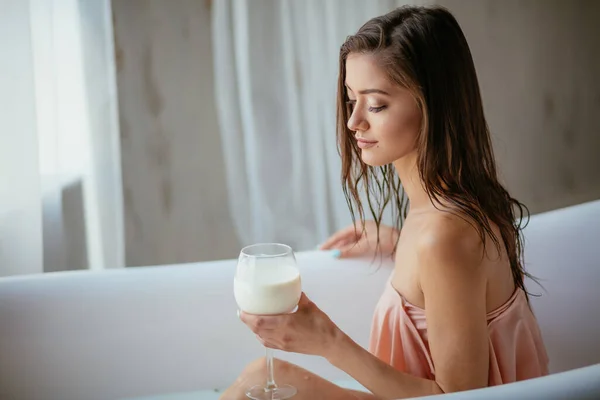 감각적으로 매력적 인 여자가 우유 한 잔으로 목욕중에 긴장을 풀고 있다. — 스톡 사진