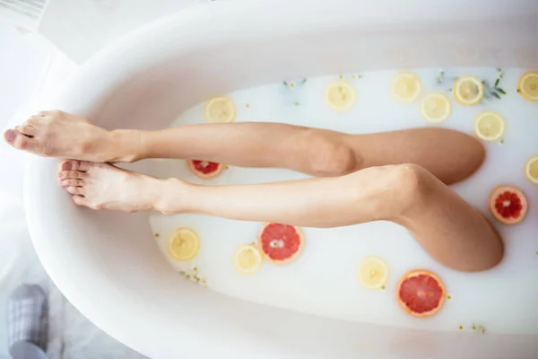 Красива сексуальна жінка в молочній ванні з квітами — стокове фото
