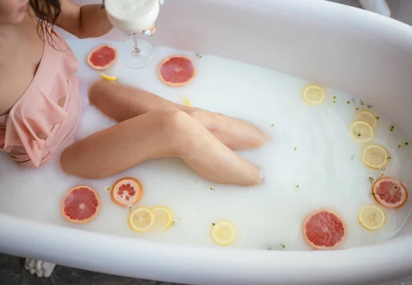 Hermosa mujer sexy en el baño de leche con flores — Foto de Stock