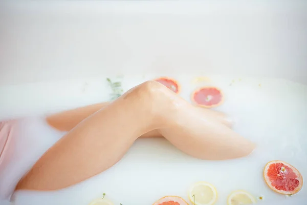 Belle femme sexy dans le bain de lait avec des fruits — Photo