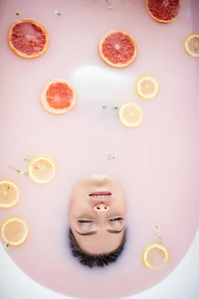 Cara de mujer en baño de leche. Spa concepto de cuidado de la piel. Rostro sano y rejuvenecimiento. — Foto de Stock