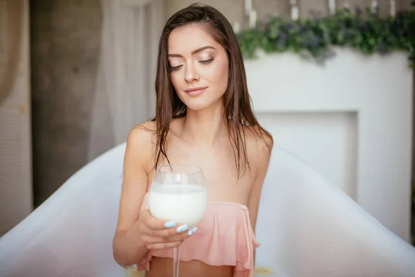 Sensual atractiva mujer relajante en baño con vaso de leche. — Foto de Stock