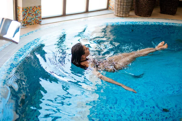 Mulher refrigeração na piscina interior no Luxury Resort. — Fotografia de Stock