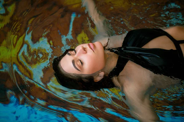 Beautiful woman in indoor spa pool, close up. Warmth, rest, relaxation