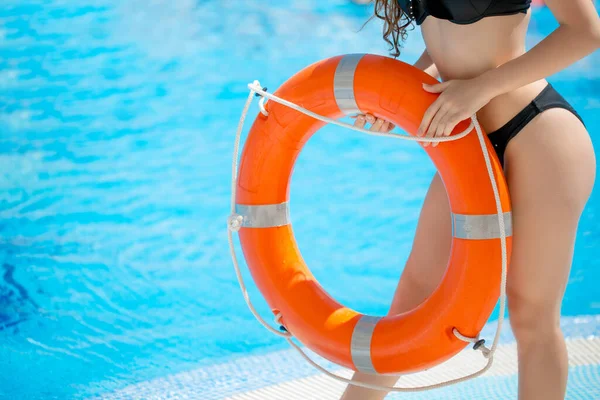 Jovem atraente está posando com anel inflável de borracha perto da piscina. — Fotografia de Stock