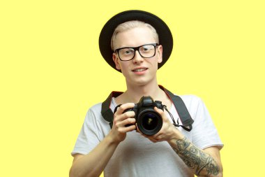 Seyahat konsepti. Fotoğraf çeken yakışıklı bir gencin stüdyo portresi..