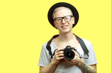 Seyahat konsepti. Fotoğraf çeken yakışıklı bir gencin stüdyo portresi..