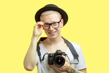 Seyahat konsepti. Fotoğraf çeken yakışıklı bir gencin stüdyo portresi..