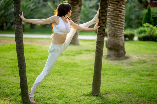 Attraktiv kvinna tränar fitness träna utomhus över naturen bakgrund — Stockfoto