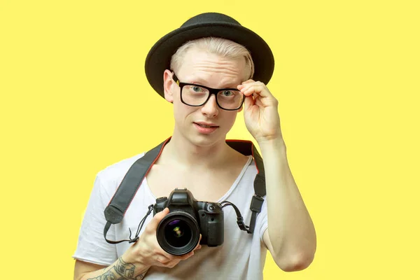 Ταξιδιωτική ιδέα. Studio πορτρέτο του όμορφου νεαρού άνδρα λήψη φωτογραφιών από την κάμερα του τηλεφώνου του. — Φωτογραφία Αρχείου