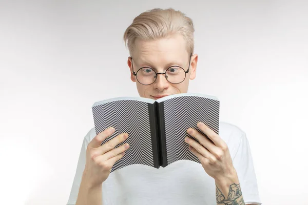 Giovane uomo biondo lettura libro su sfondo bianco con spazio di copia — Foto Stock