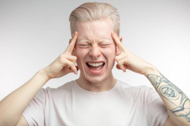 Bitcoin fiyatlarındaki ani düşüşten bıkmış, parmaklarını şakaklarda tutan adam.