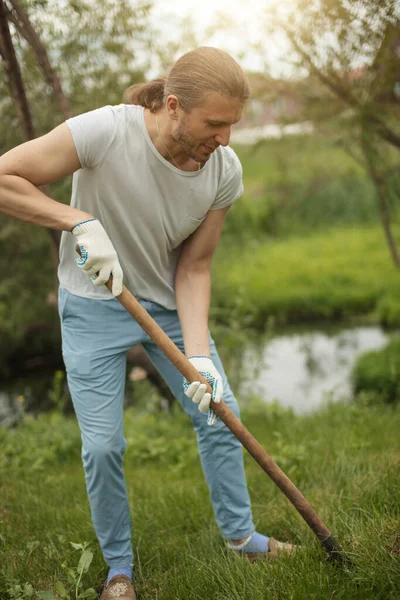 Adult man digs a hole to plant a tree outdoors in park. — Stock Photo, Image