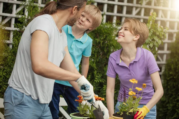 Ibu muda berkebun di depan atau belakang halaman dengan dua anak kecilnya yang lucu — Stok Foto
