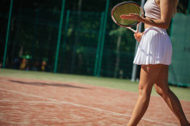 Sahada tenis raketiyle kadın bacakları portresi. resmi kapat