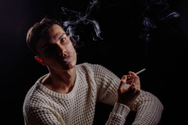 Sigara içen yakışıklı bir adam.