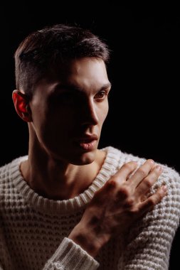 Beyaz tişört ve güneş gözlüğü takan yakışıklı bir erkek mankenin stüdyo fotoğrafı.