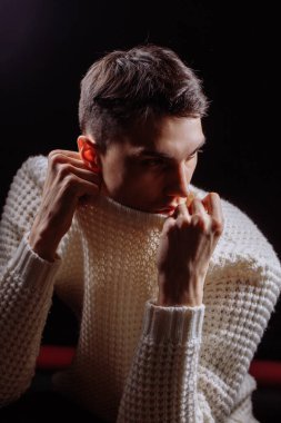 Beyaz tişört ve güneş gözlüğü takan yakışıklı bir erkek mankenin stüdyo fotoğrafı.