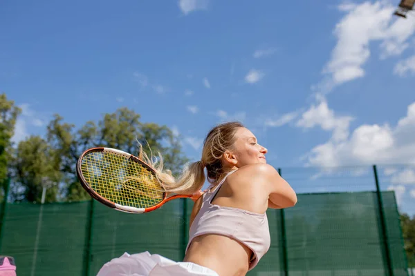 Schöne Tennisspielerin serviert draußen — Stockfoto