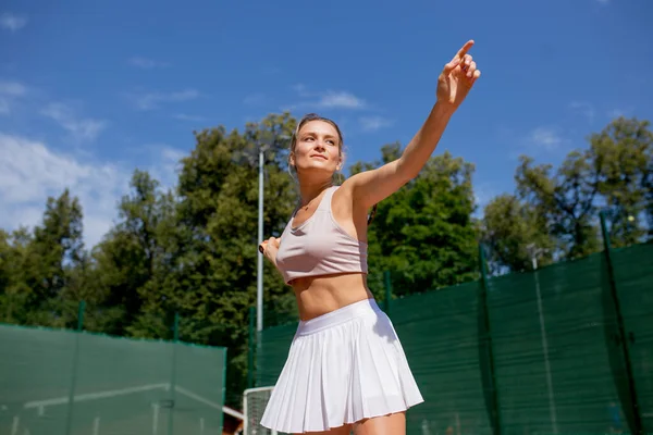 Sahada tenis oynamak için top servis eden bir kadın. — Stok fotoğraf