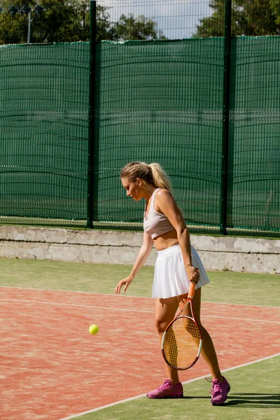 Mujer sirviendo la pelota para un partido de tenis en la cancha —  Fotos de Stock
