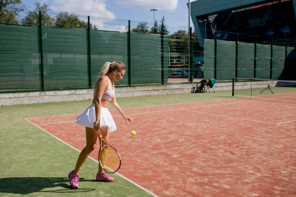 Mujer sirviendo la pelota para un partido de tenis en la cancha — Foto de Stock