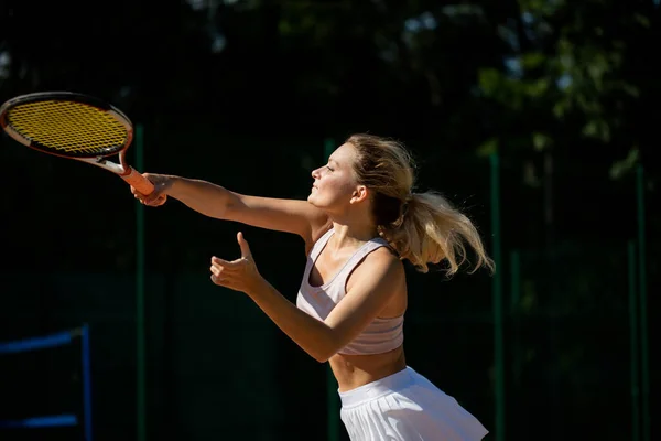 Frau serviert den Ball für eine Partie Tennis auf dem Platz — Stockfoto