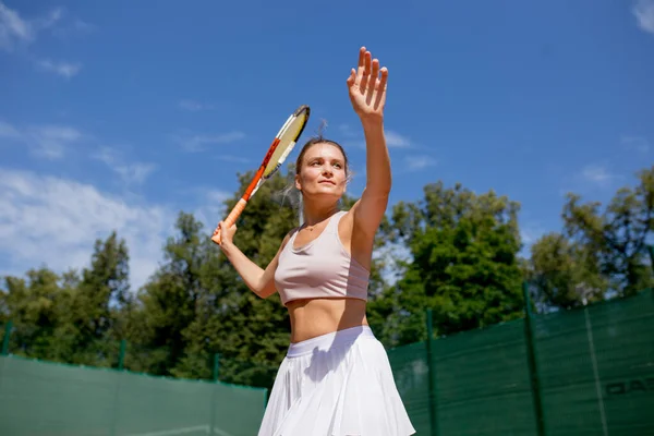 Mujer sirviendo la pelota para un partido de tenis en la cancha — Foto de Stock