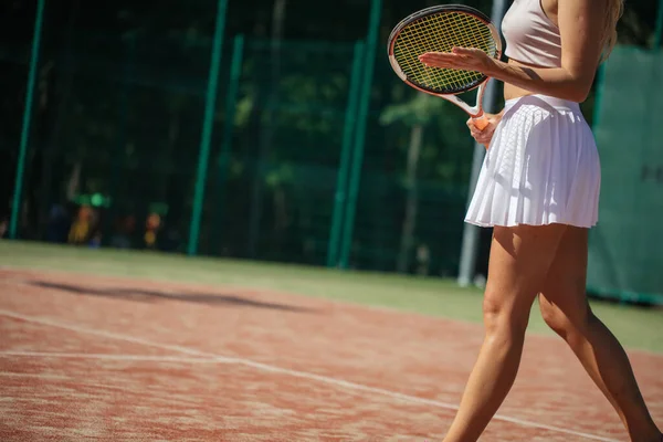 Portret van vrouwelijke benen met tennisracket op het veld. close-up afbeelding — Stockfoto