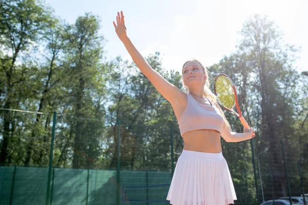 Sahada tenis oynamak için top servis eden bir kadın. — Stok fotoğraf