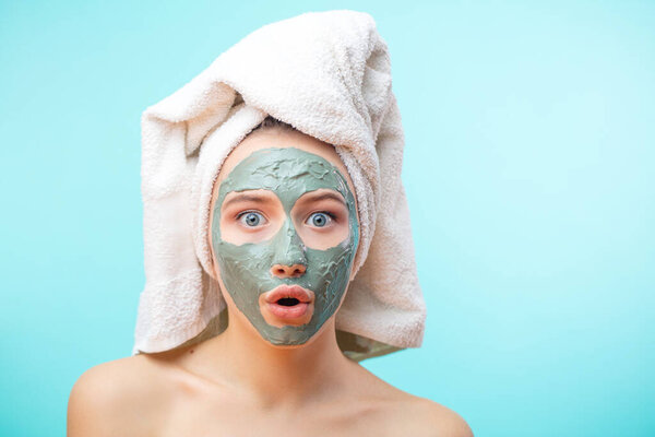 The girl in a mask for the face with a towel on his head