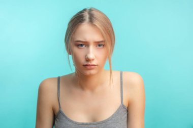 Hoşnutsuz bir kadın, üzgün, mavi stüdyo geçmişi yüzünden izole edilmiş..