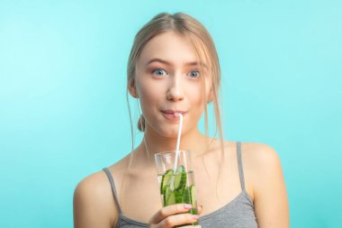 Mavi arka planda tişört giymiş heyecanlı bir kadın..