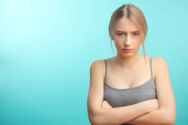 Hoşnutsuz bir kadın, üzgün, mavi stüdyo geçmişi yüzünden izole edilmiş..