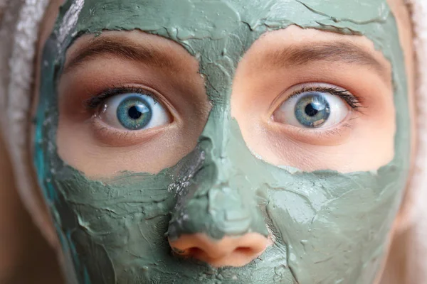 Macro tiro cara de mujer con máscara facial de arcilla en la cara aislada, clos up, macro —  Fotos de Stock