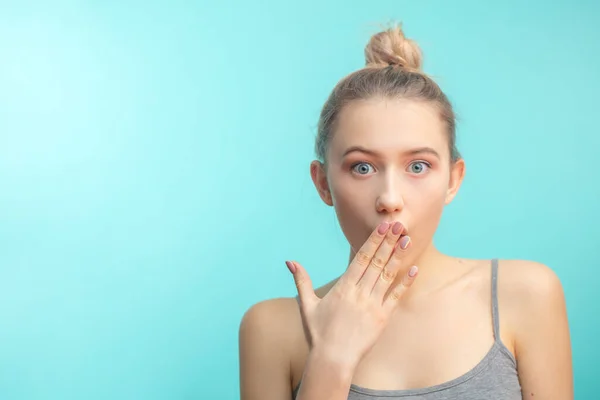 Young attractive woman with hair knot staring at camera with shoked expression — Stock Photo, Image