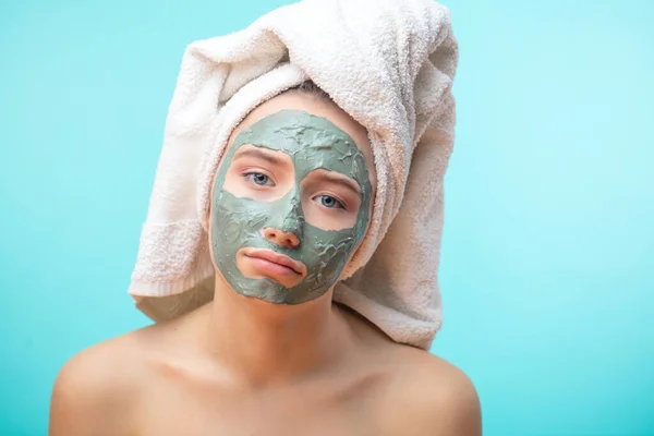 Remaja tidak bahagia perempuan dengan masker tanah liat hitam wajah membuat terapi jerawat di spa — Stok Foto