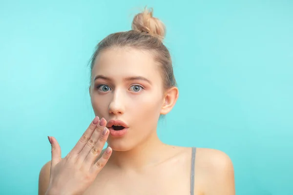 Joven atractiva mujer con el nudo del pelo mirando fijamente a la cámara con expresión shoked — Foto de Stock