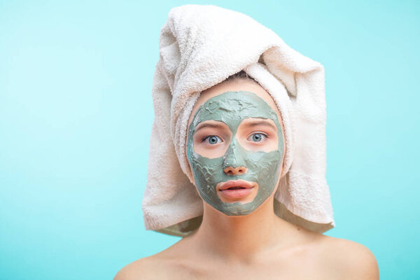 The girl in a mask for the face with a towel on his head