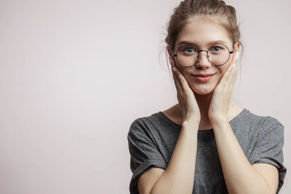 Schockiertes Weibchen mit verdutzten Augen, die in die Kamera schauen, die Hände in der Nähe der Wangen — Stockfoto