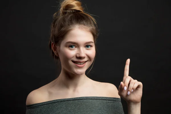 Bonne idée ici, femme souriante isolée avec le doigt pointée vers le haut. — Photo