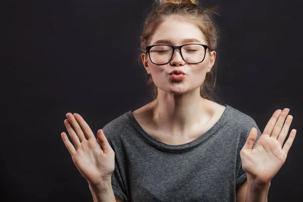 Linda joven encantadora en gafas de sol redondas de pie y el envío de beso sobre fondo rosa — Foto de Stock