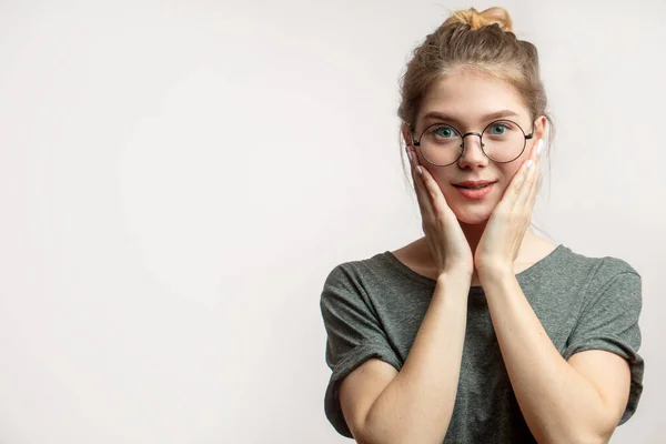 Mujer conmocionada con los ojos con micrófonos mirando a la cámara, las manos se sostiene cerca de las mejillas — Foto de Stock