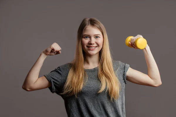 Attrayant jeune femme de fitness tenant haltère. Plan studio. — Photo