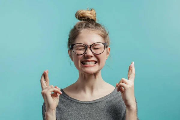 Retrato de una adolescente mostrando gesto con los dedos cruzados aislados sobre un fondo blanco y mirando hacia arriba —  Fotos de Stock