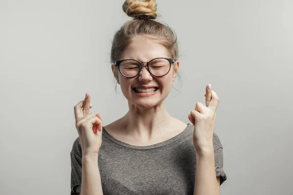 Retrato de una adolescente mostrando gesto con los dedos cruzados aislados sobre un fondo blanco y mirando hacia arriba — Foto de Stock