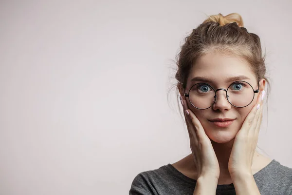 Mujer conmocionada con los ojos con micrófonos mirando a la cámara, las manos se sostiene cerca de las mejillas — Foto de Stock